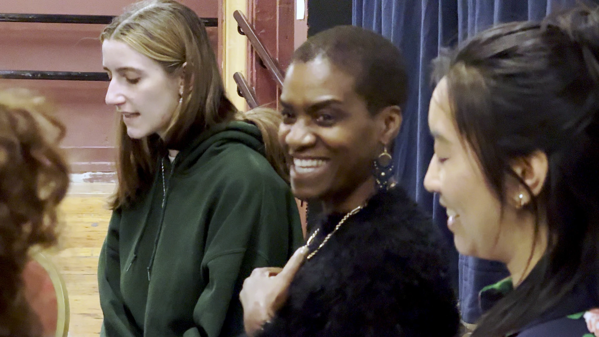 Jennifer John smiles as women sing around her