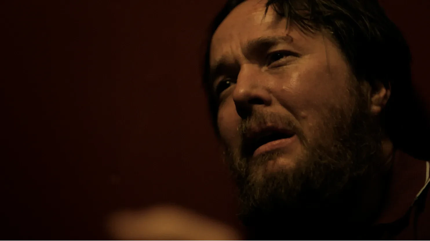 A distraught looking man looks off into the distance. 
