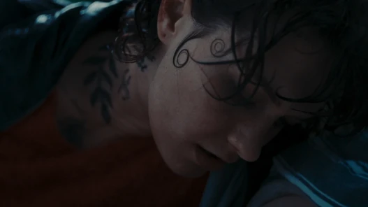 A woman with spirals in her hair leans on a man's chest.