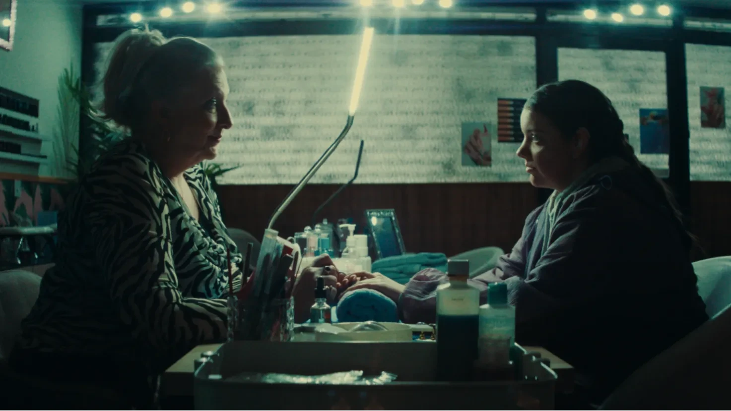 Donna & Saskia sit opposite eachother in a nail salon.
