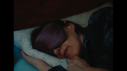 A woman in a sleep mask in bed