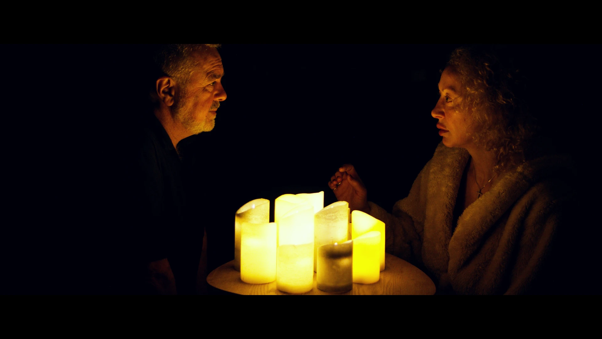 Emma meets her deceased husband Sam, over candlelight.