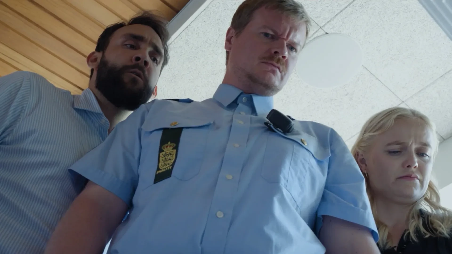 Thomas, Anje, and a police officer inspecting the contents of a chest freezer