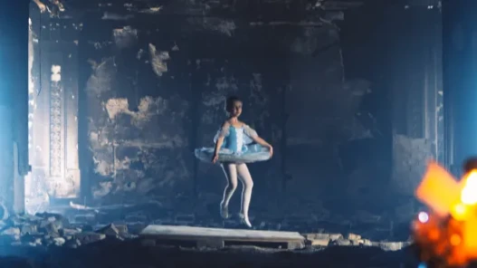 A child ballerina dancing in a rubble-filled building