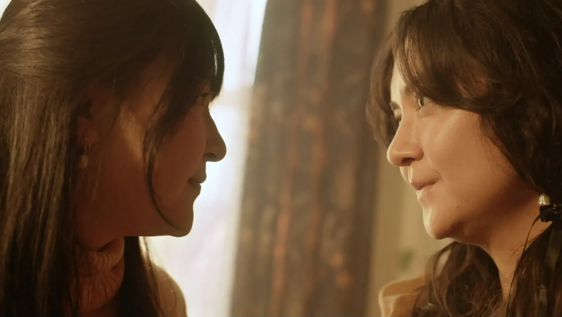 Two women look at each other.