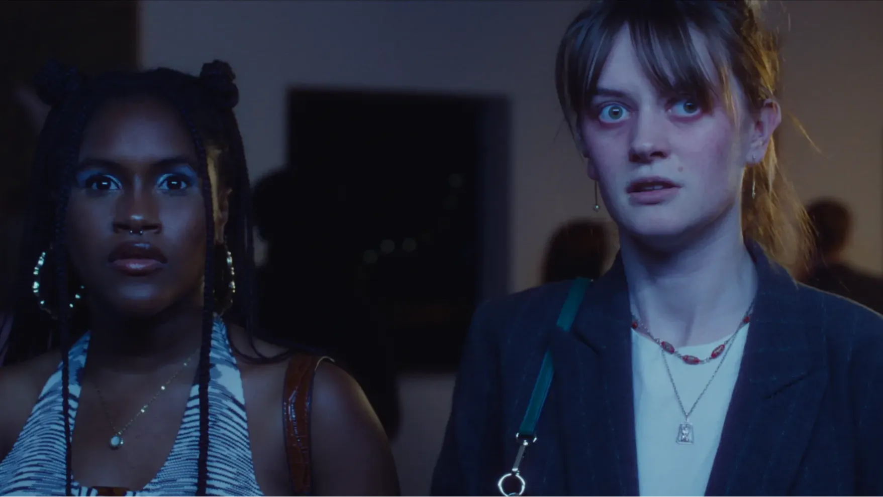 Two girls looking at something that horrifies them