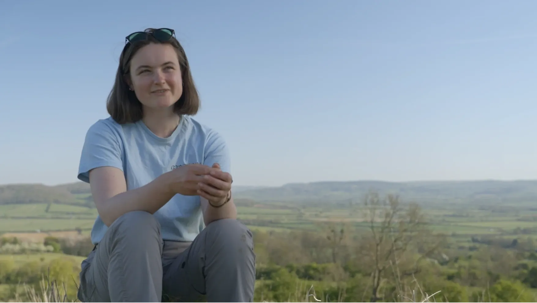 A young farmer, Lucy Robbins, speaking to camera in a spring field in the Cotswolds