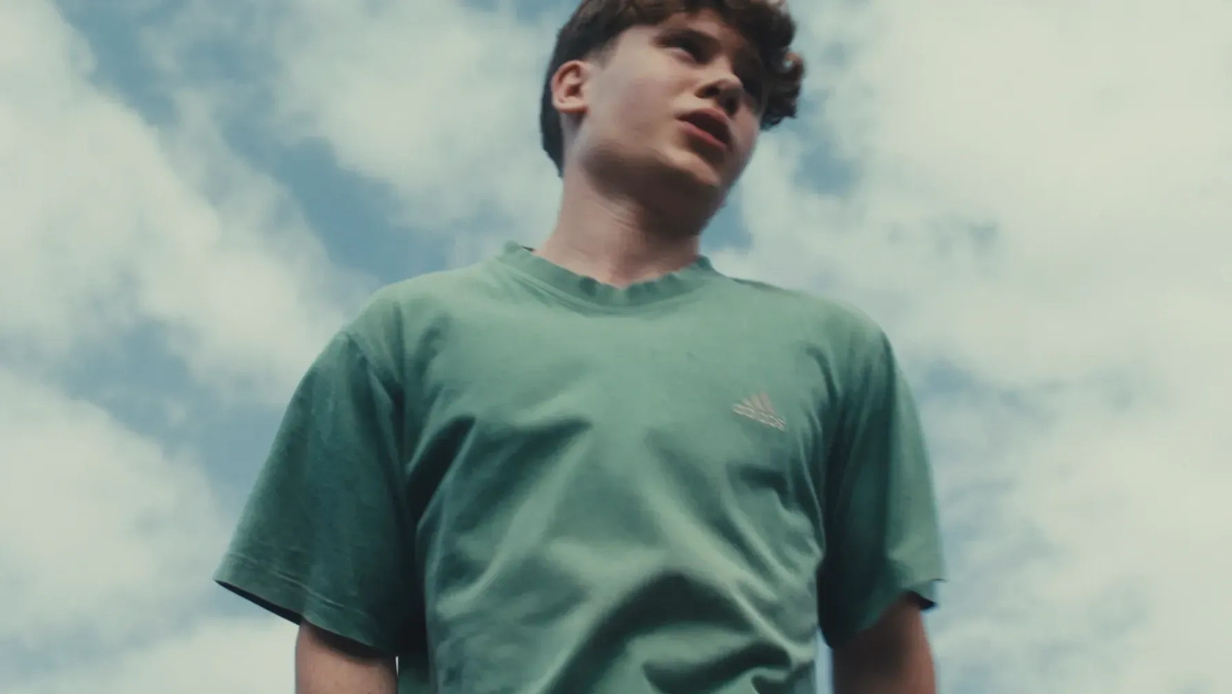 A teenage boy contemplates whilst jumping on the trampoline
