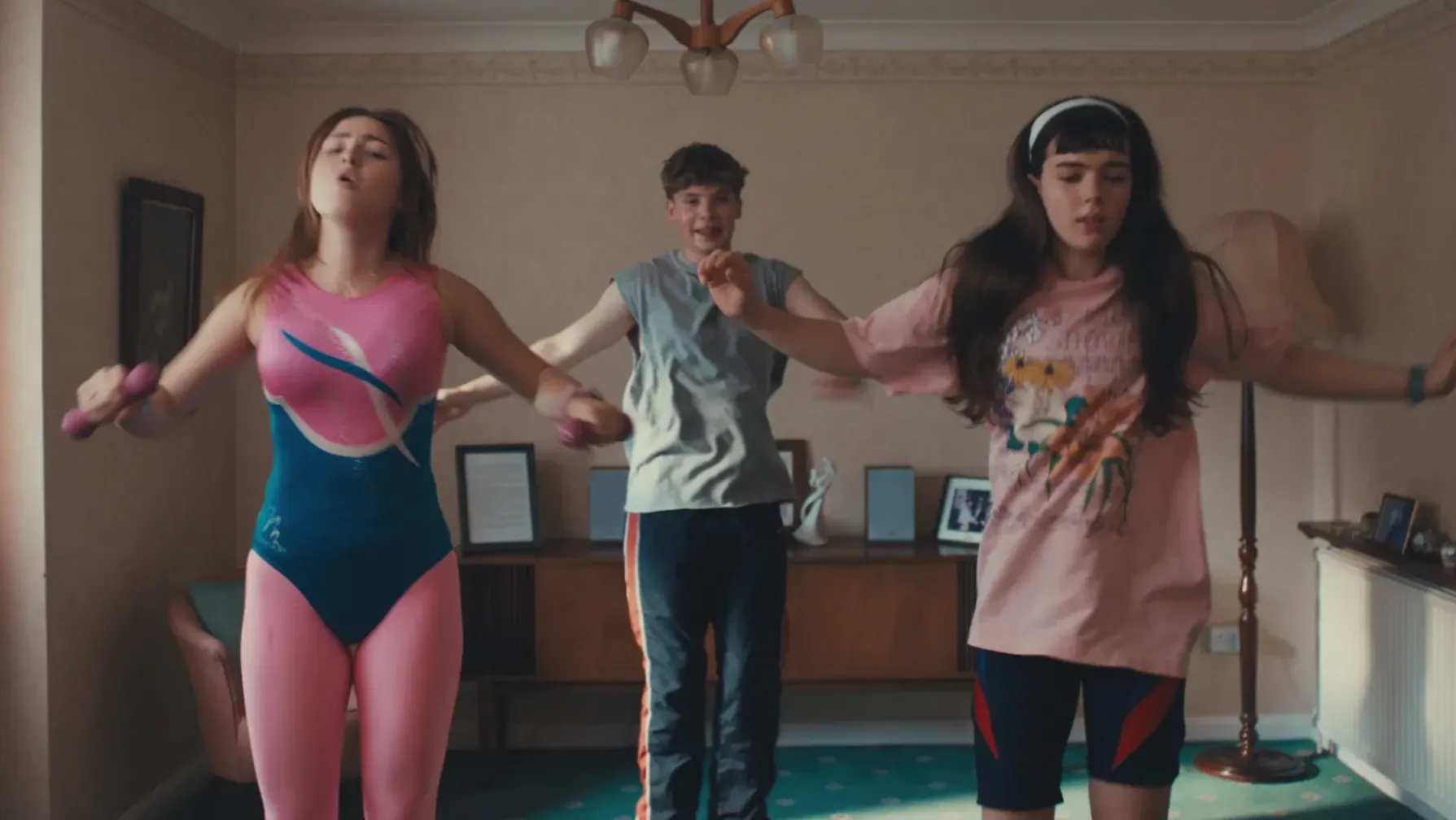 A teenage boy dances to the workout video with girls