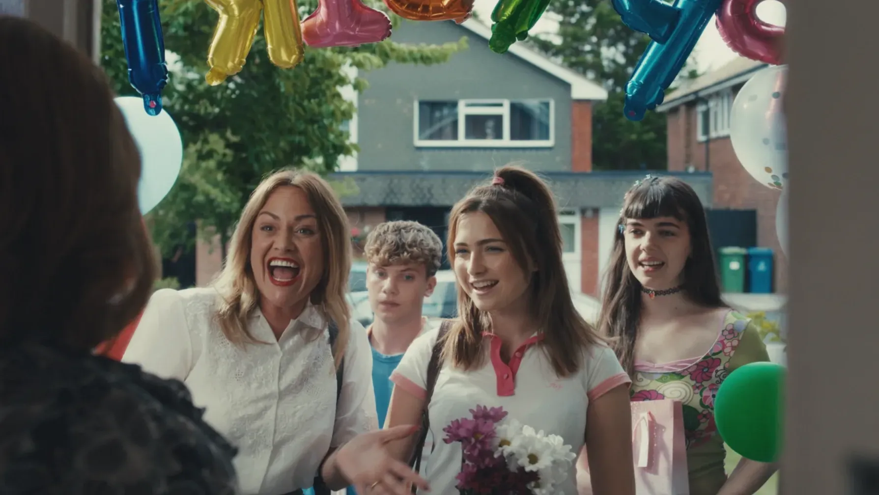 A family group arrive at a house for a birthday party