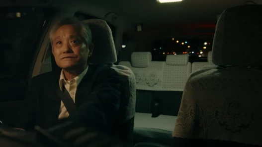 A man driving a taxi in the nighttime