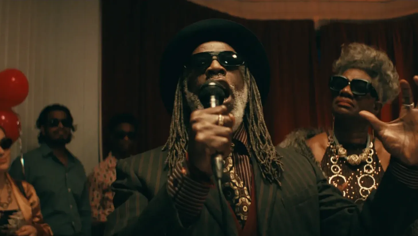 A man in sunglasses praying at a wedding.