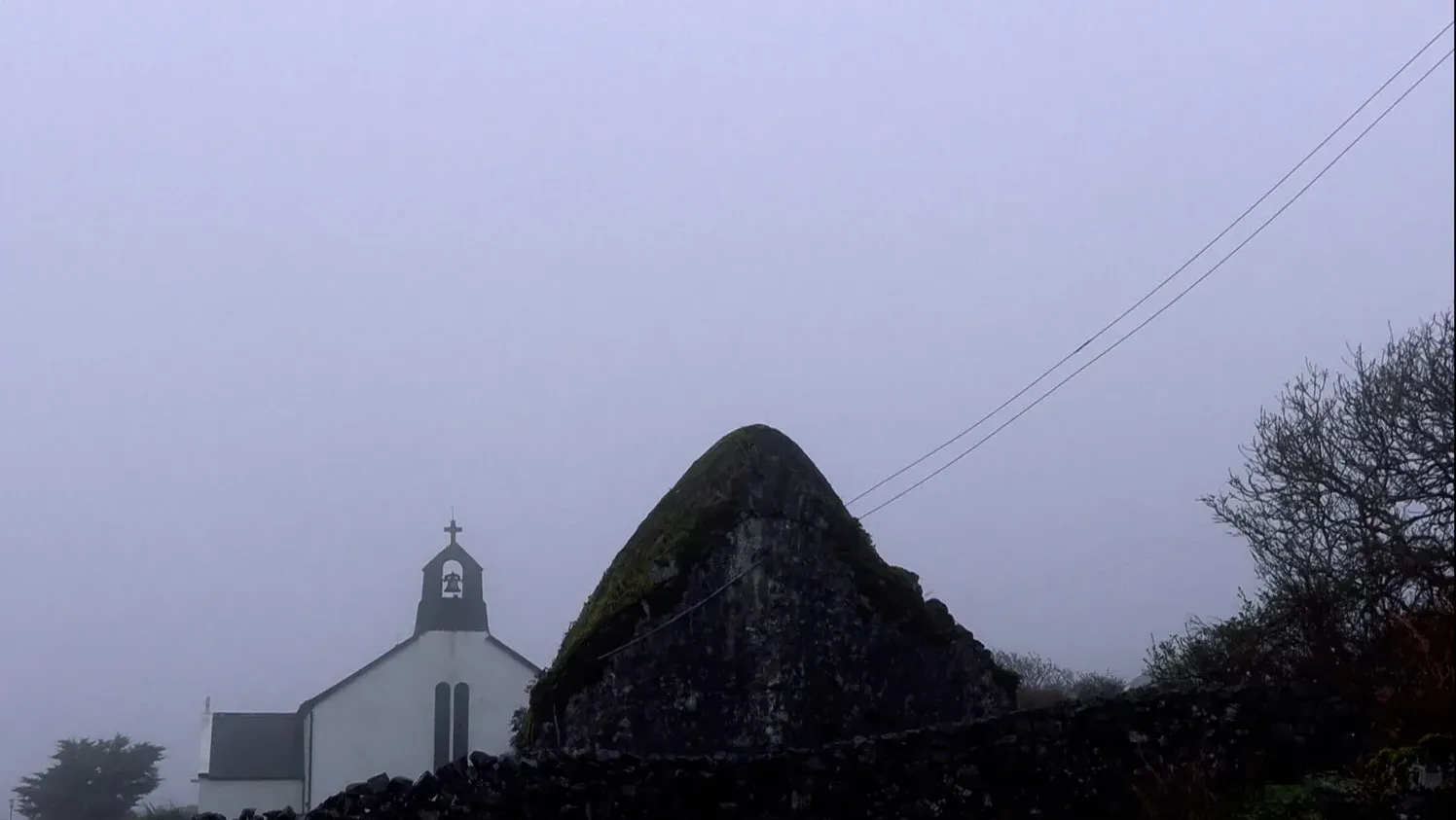 Landscape image of an old church in fog on the Aran Islands