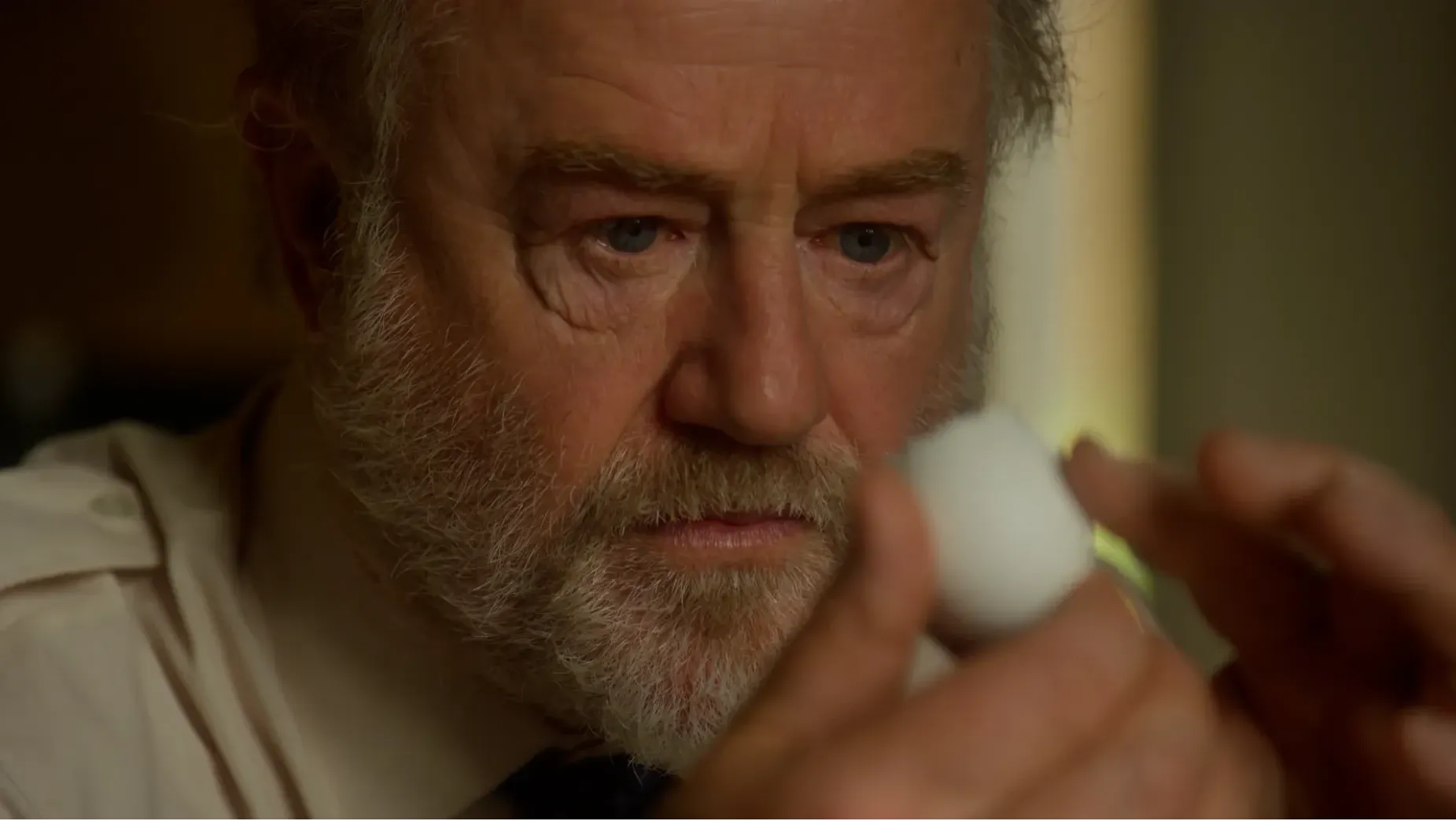 An older man examines an egg shell