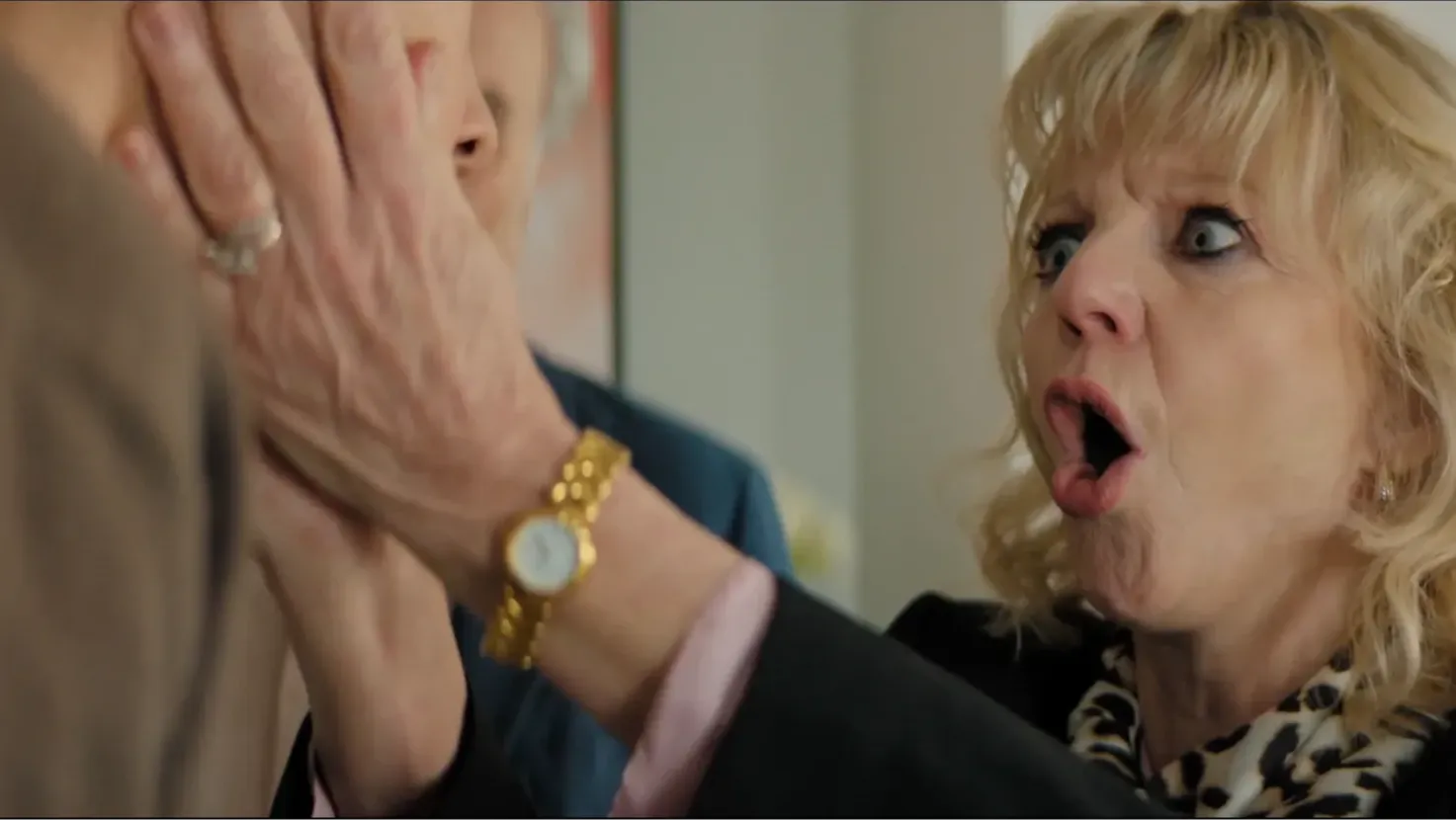 A woman in shock holding man's face