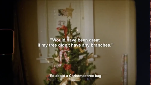 A super 8 image of a christmas tree. Text says "Would have been great if my tree didn't have any branches.' - Ed about a Christmas tree bag.