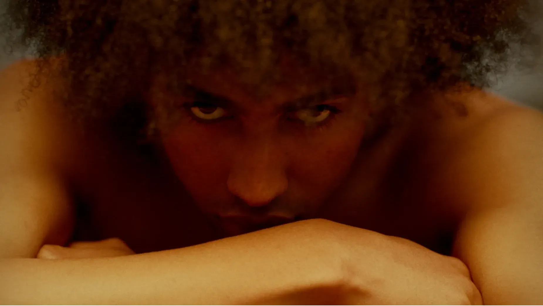 Young mixed race male, looking direct into camera with a sinister, cold glare.