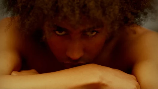 Young mixed race male, looking direct into camera with a sinister, cold glare.