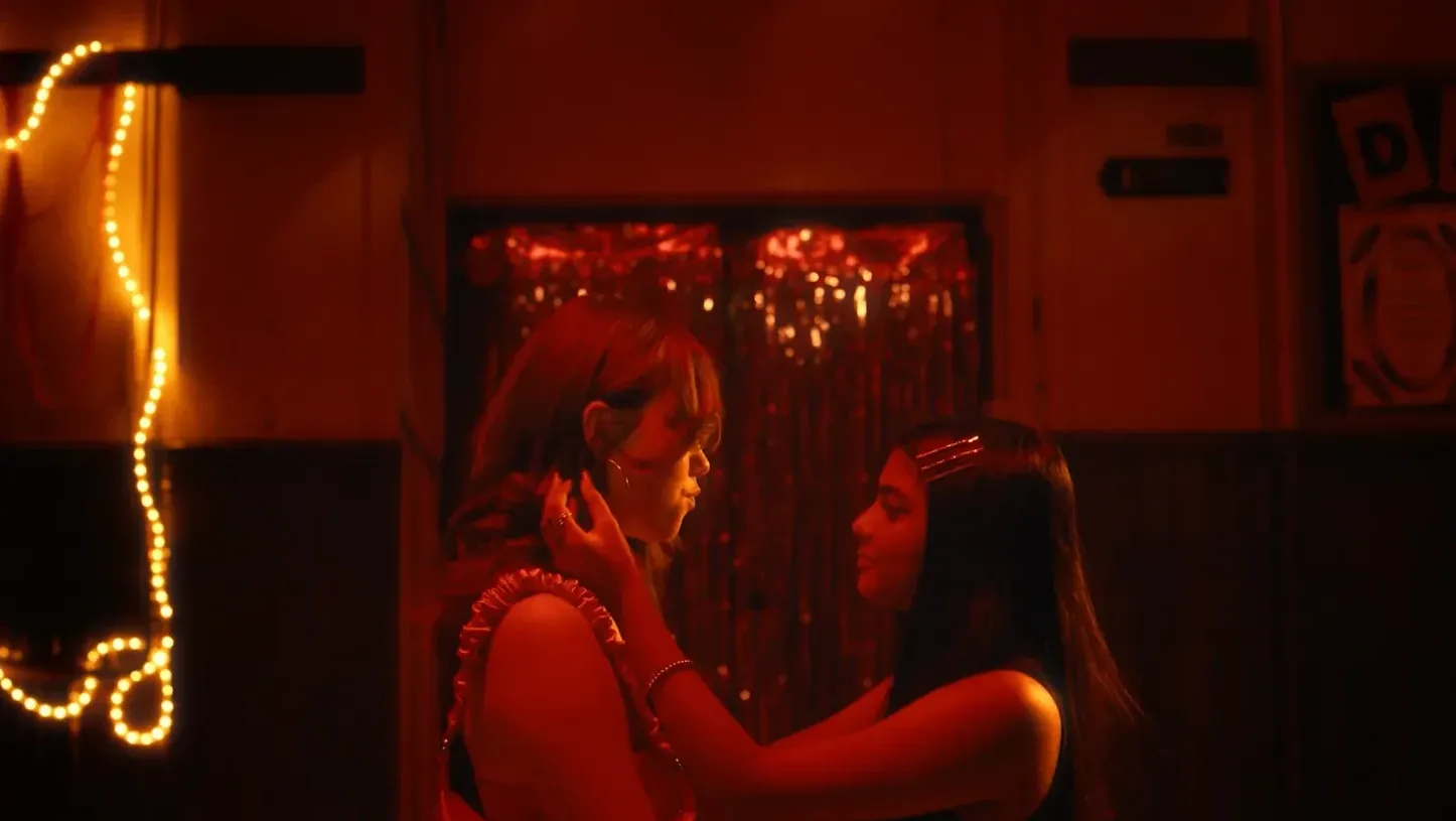 Two young girls embrace at a disco