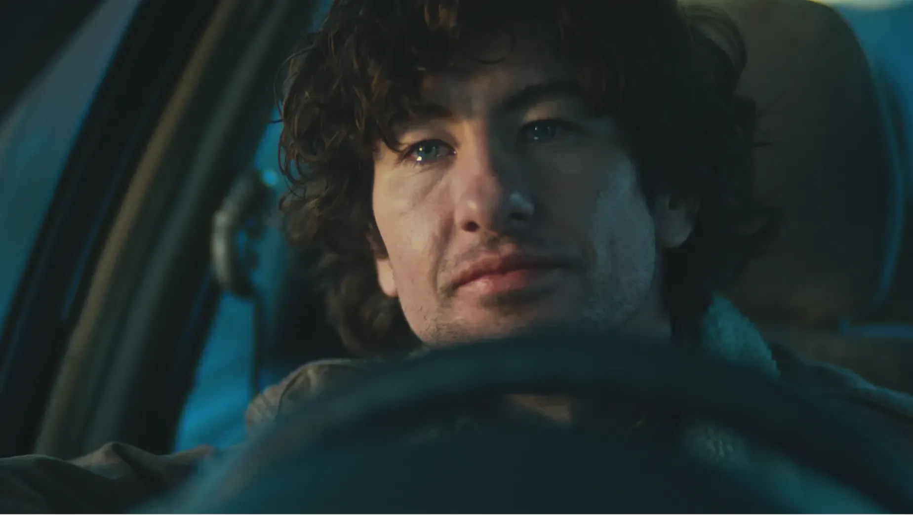 Brown-haired, blue-eyed man in his thirties gazes to the left of frame with tears in his eyes as he is moved by positive emotion