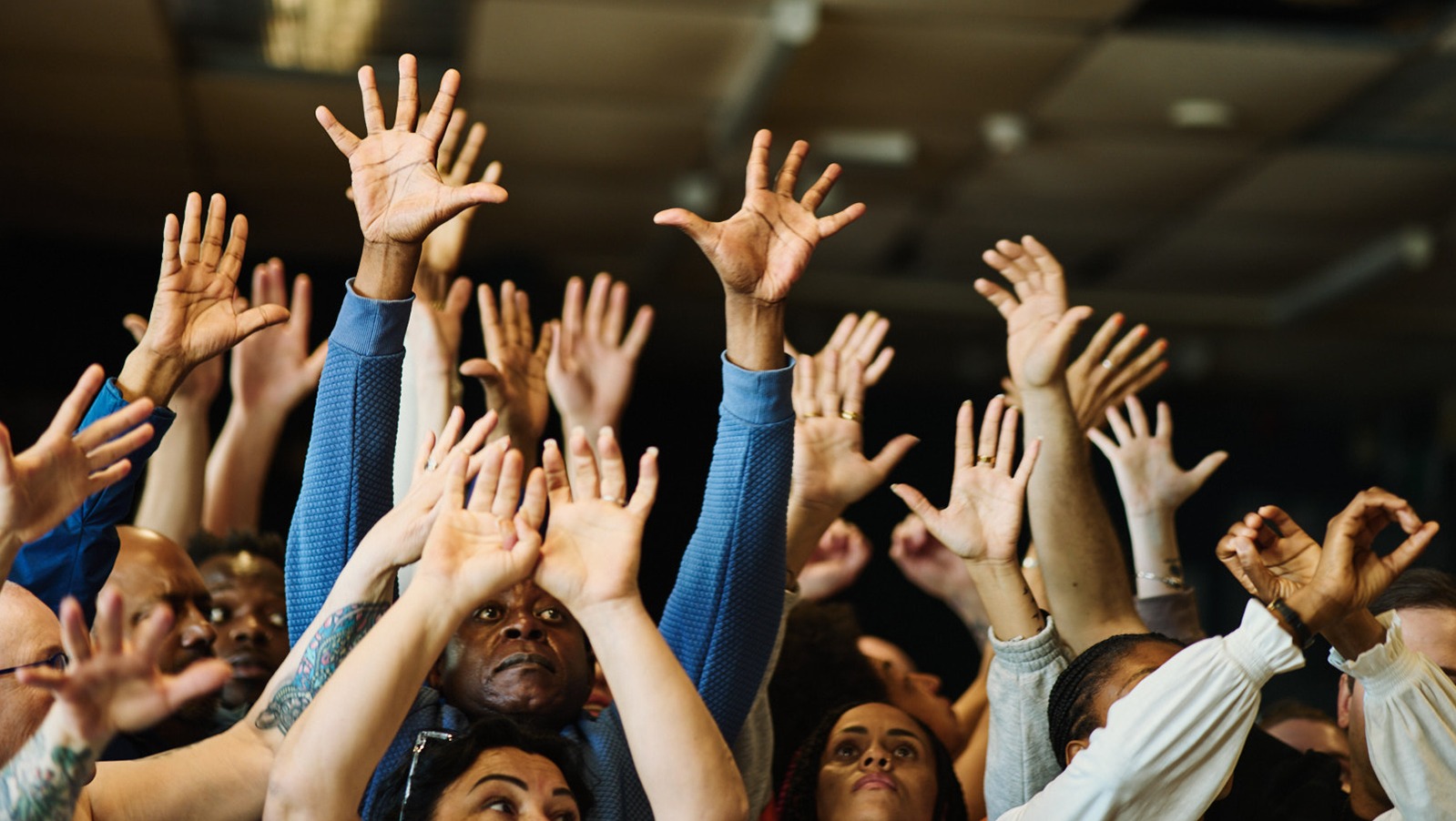 A group of people raise their hands