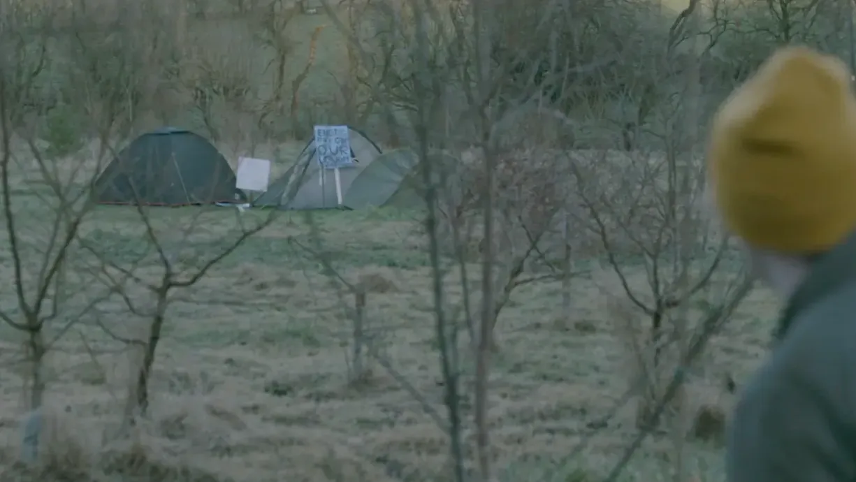 Seen from behind a man looks at an encampment