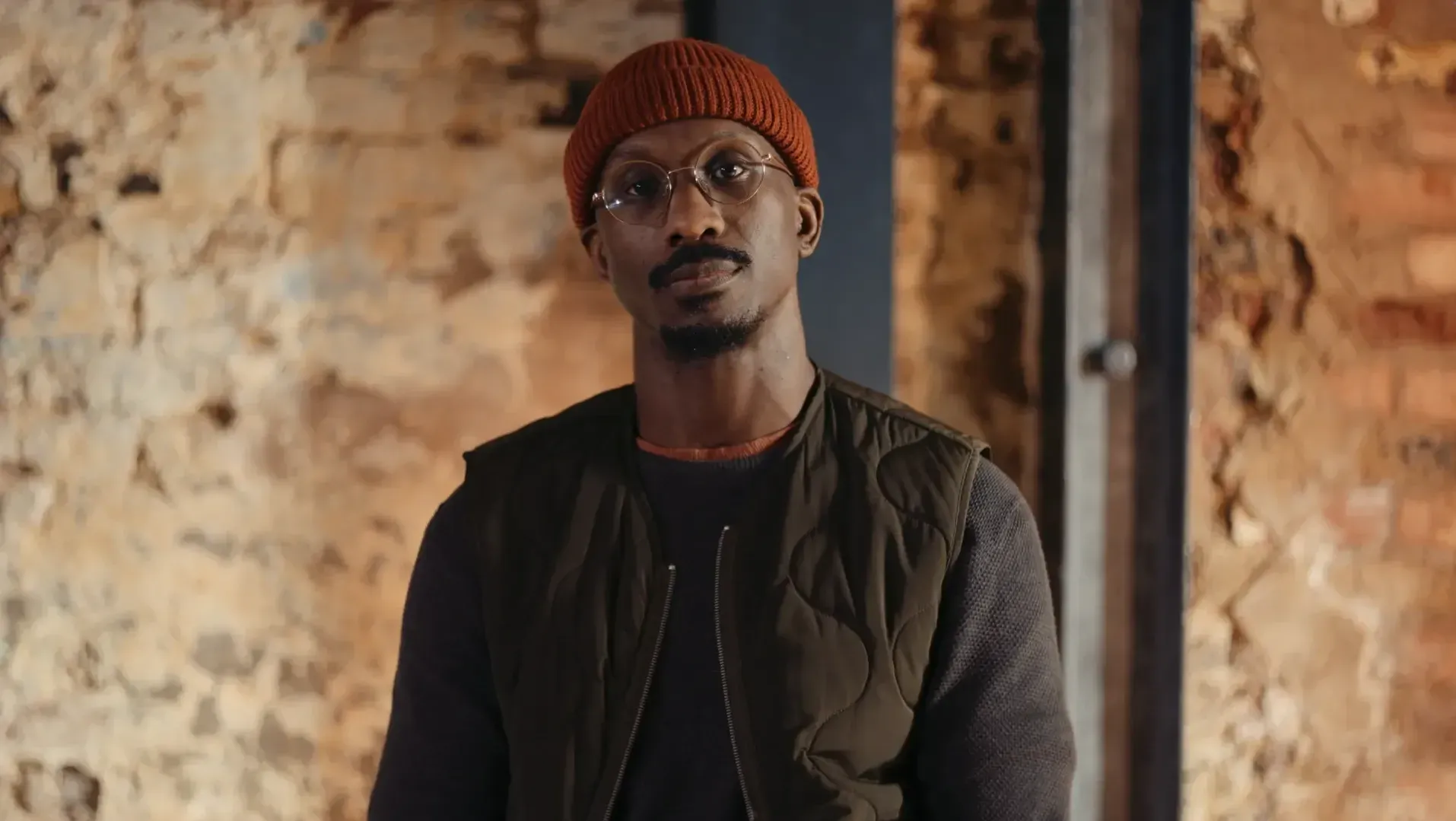 Documentary interview image. A black man wearing glasses in looking directly into the camera.
