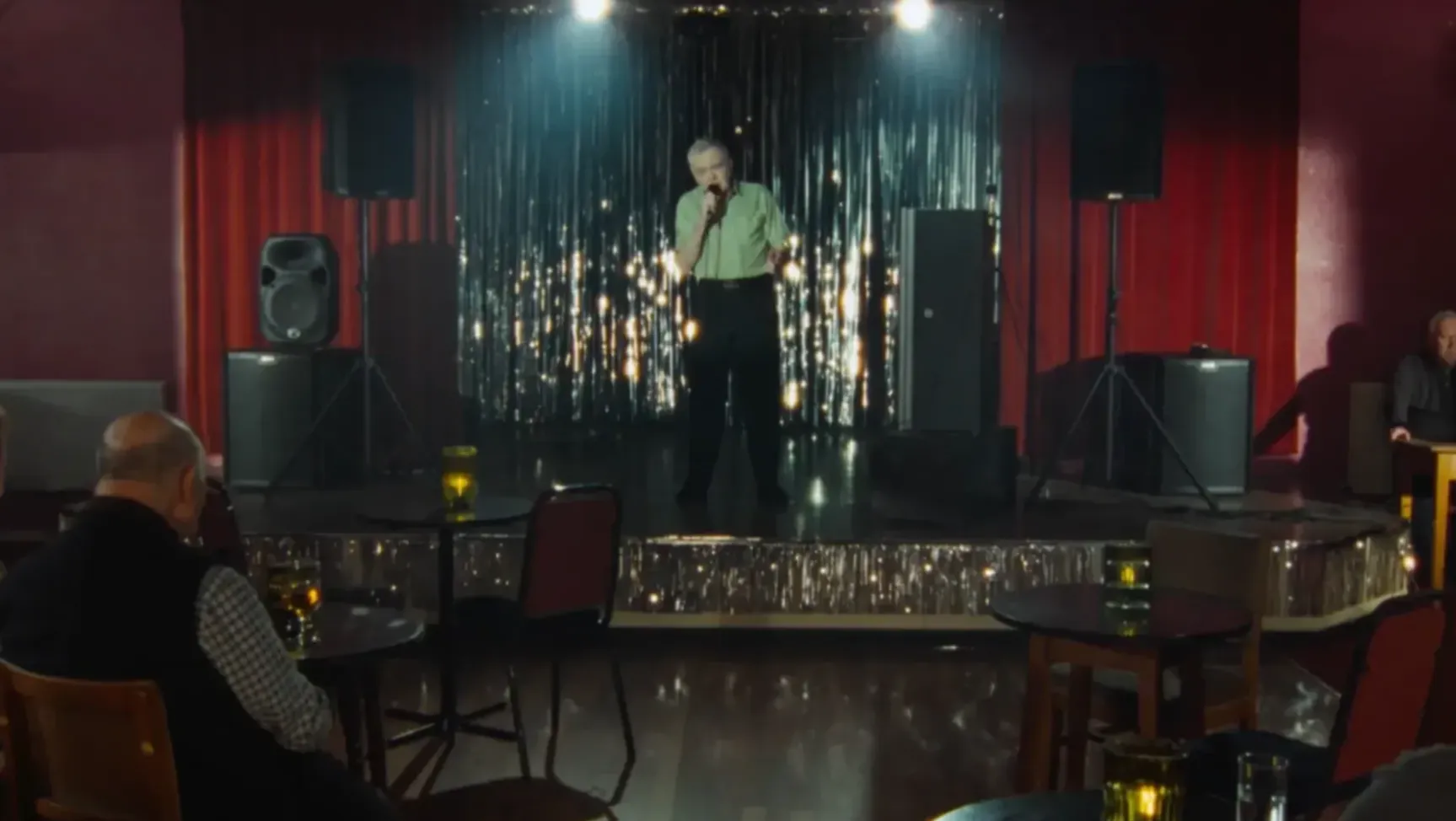 A man is performing a song at a karaoke bar.
