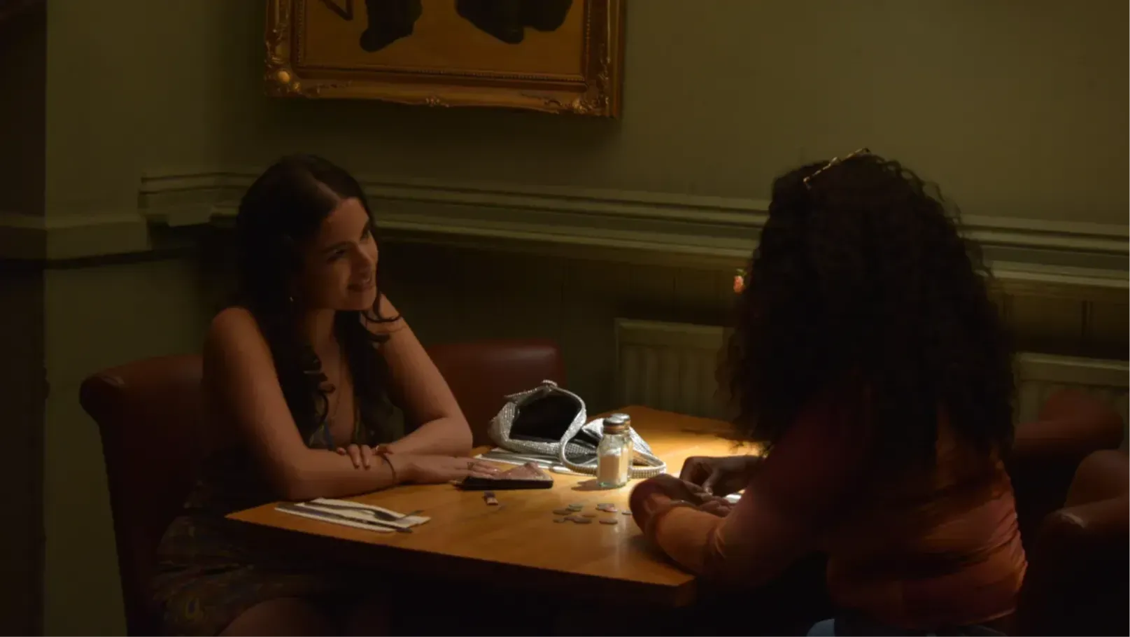 Two young girls sit accross from each other at a table