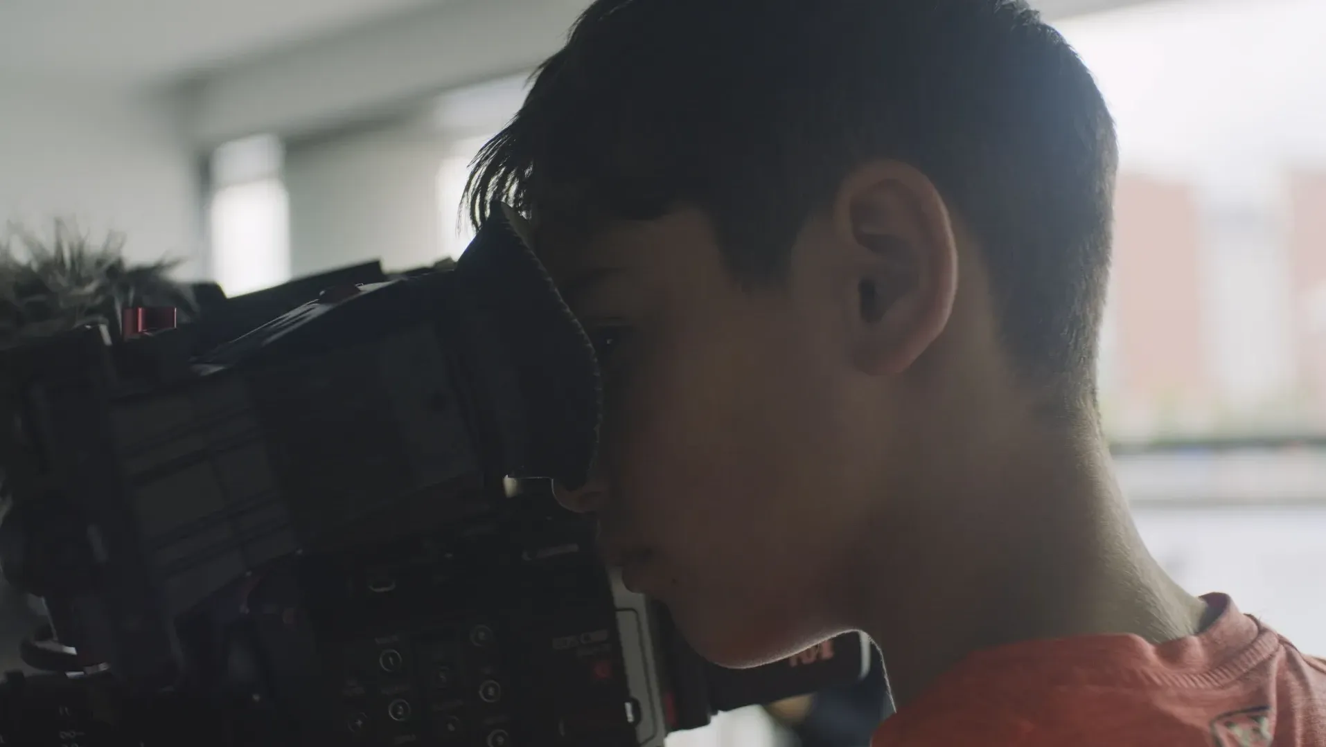 A child looking through a camera viewfinder