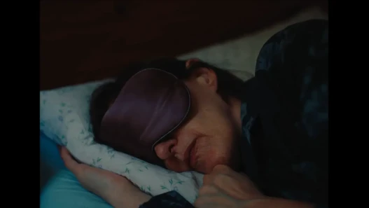 A woman in a sleep mask in bed 