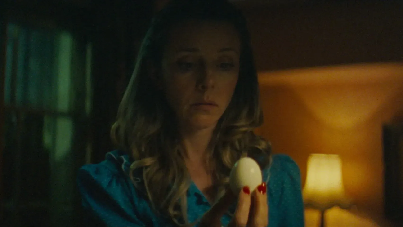 A woman looking suspiciously at an egg