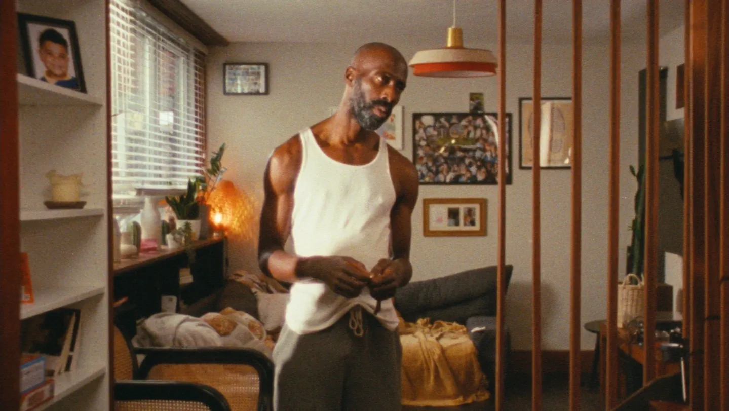 A man stands in an empty room, looking sad, holding keys