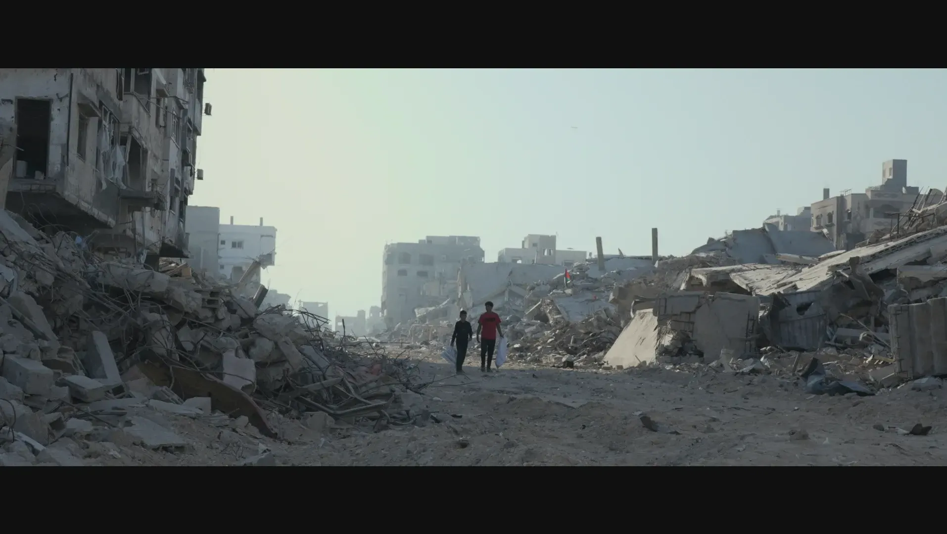 Children walking through rubble of city.