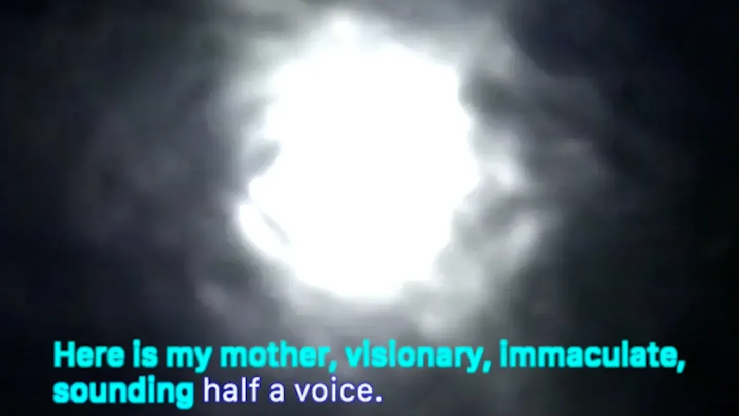 A warped reflection of the sun in water, karaoke-style text in lower half of frame: 'Here is my mother, visionary, immaculate, sounding half a voice.'