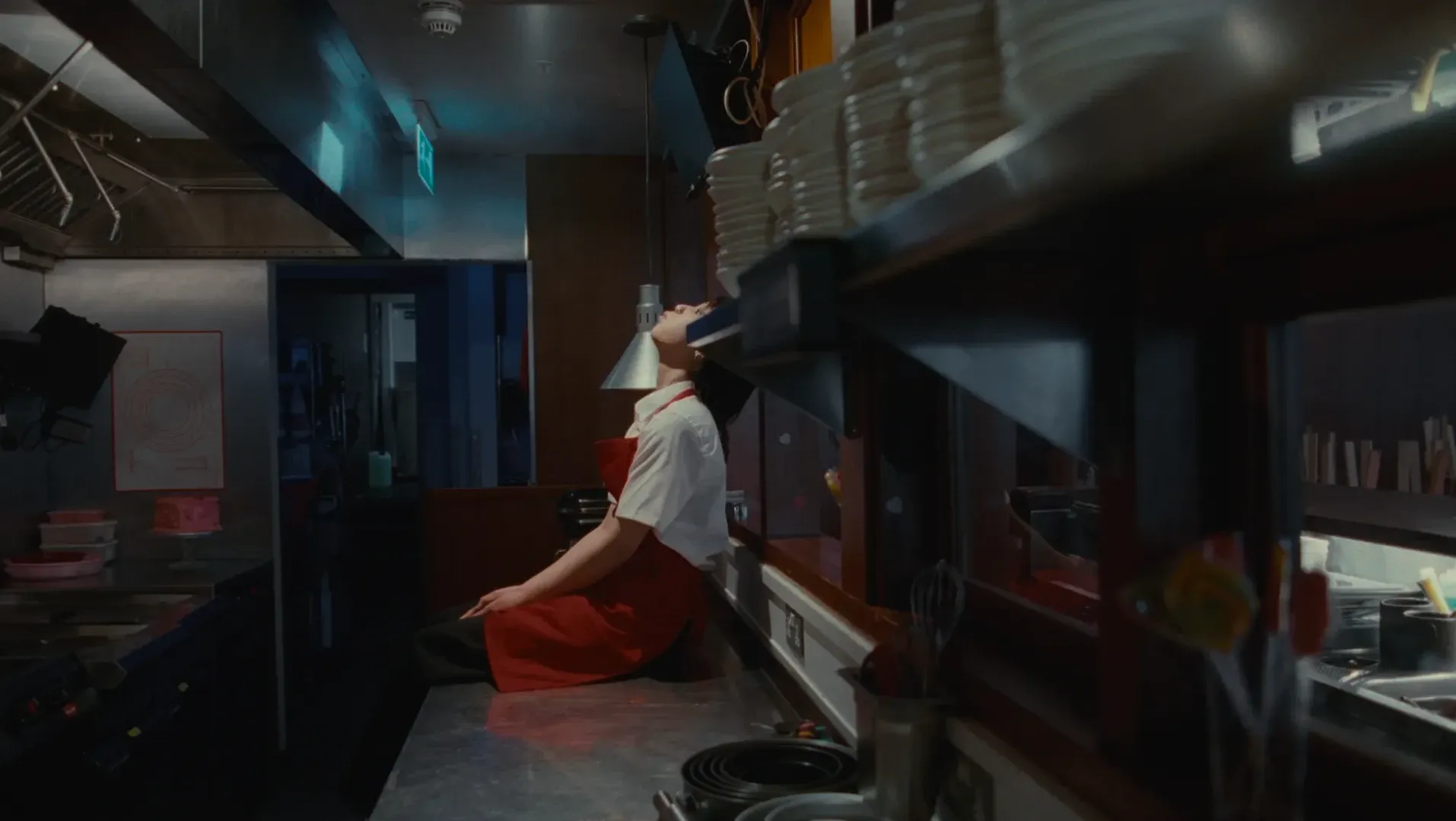 A woman leans back against a kitchen counter