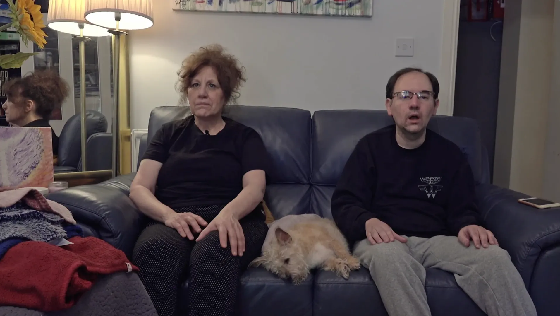 Paolo and his mother, Loretta, sitting on the sofa with per dog between them.
