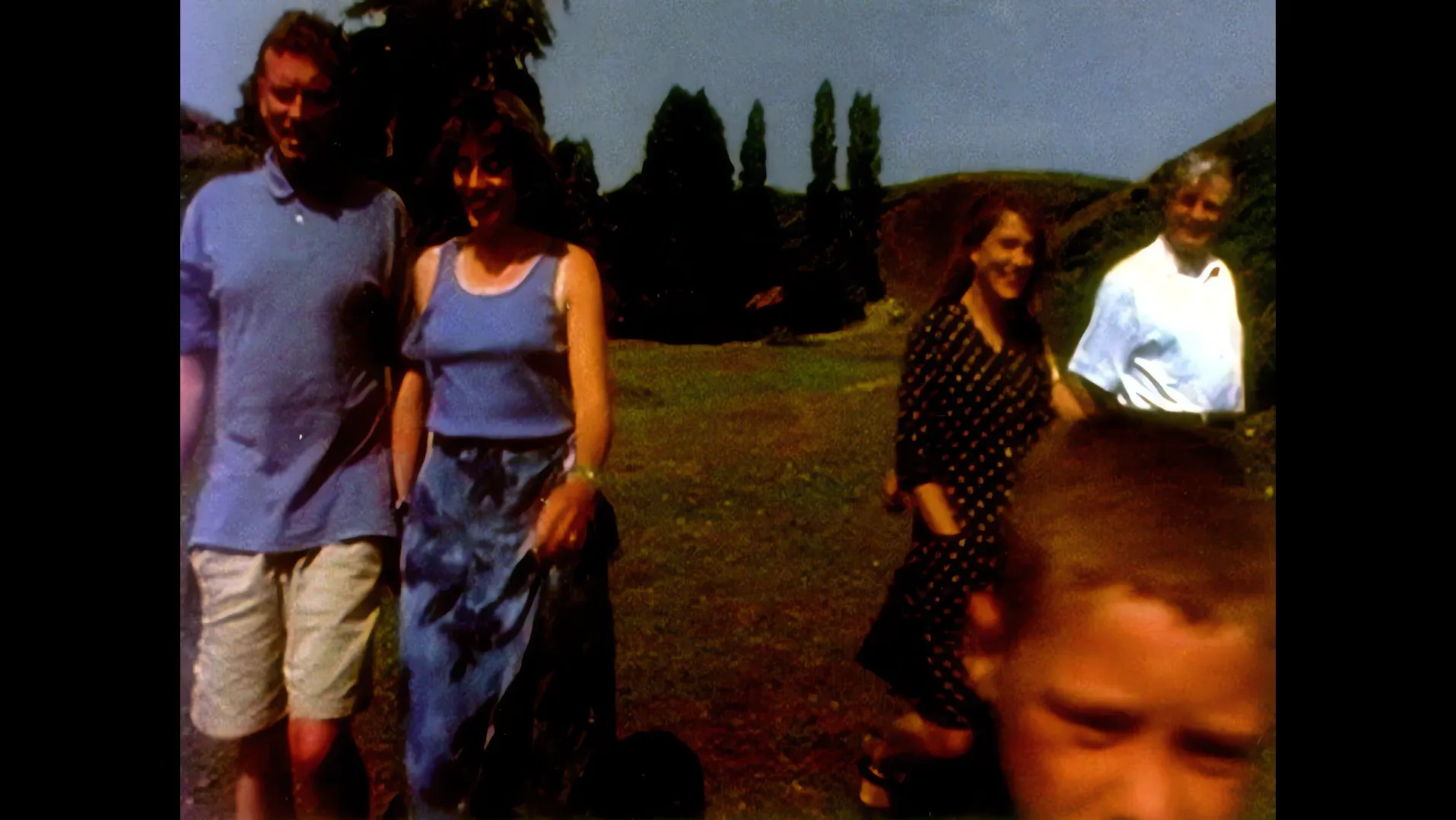 A family photograph of adults and a boy in a park