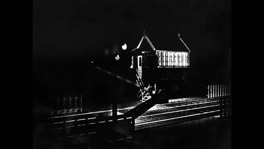A dark, high-contrast photograph of a house with a lit window at night