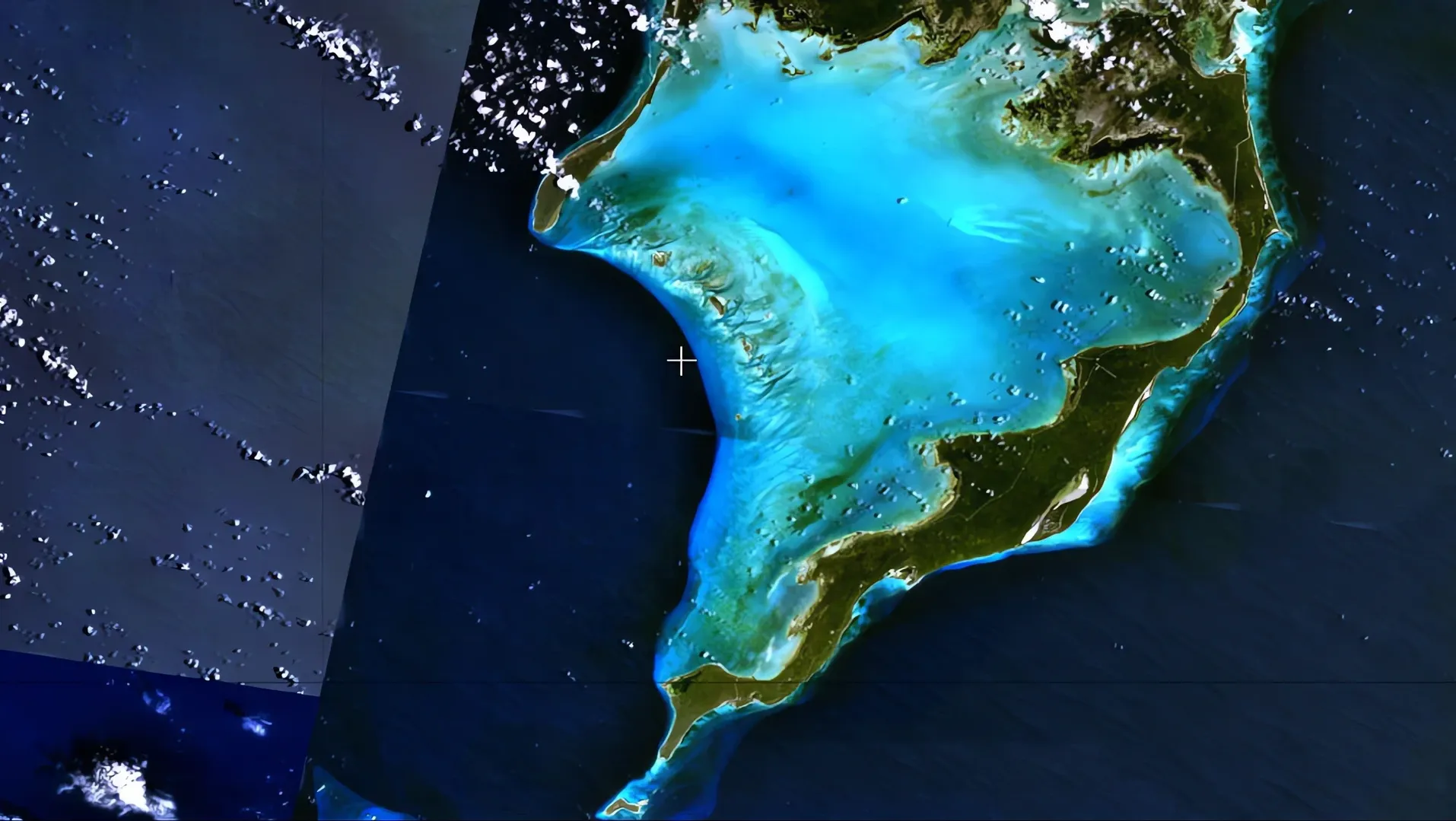 Satellite image of a coastline and blue shallow seas seen from above