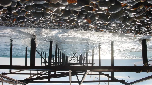 An upside-down view of a pier and its reflection over the sea