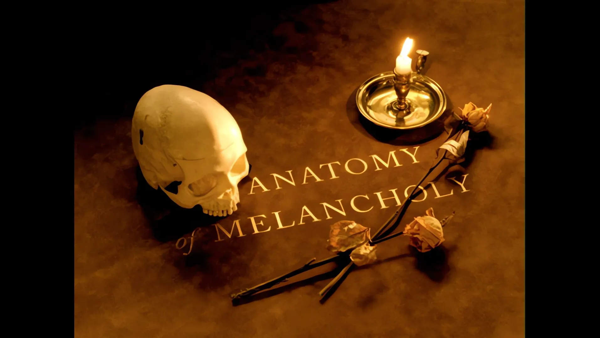 A skull, a candle and the words Anatomy of Melancholy on a dark table
