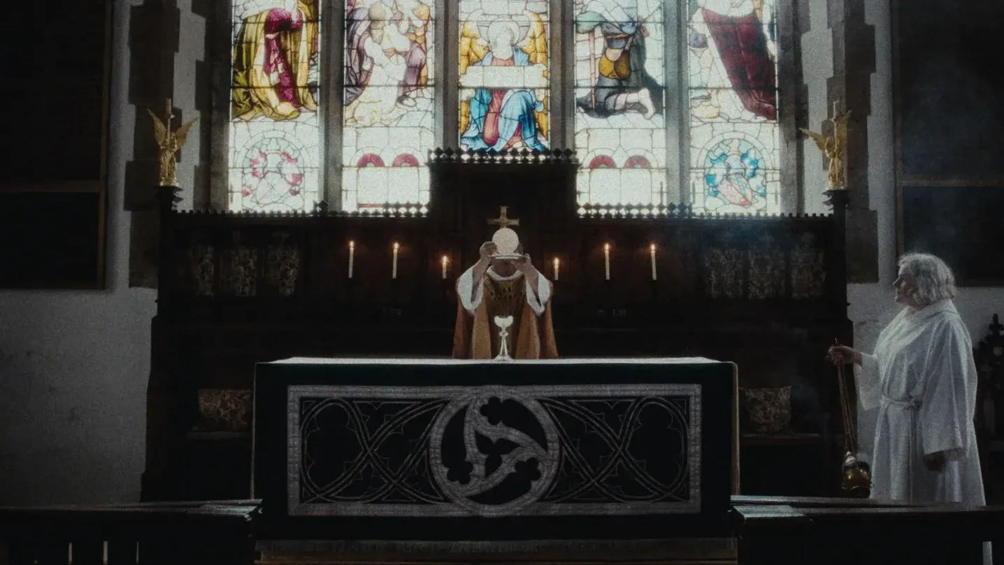 Image of a vicar holding up the eucharist.